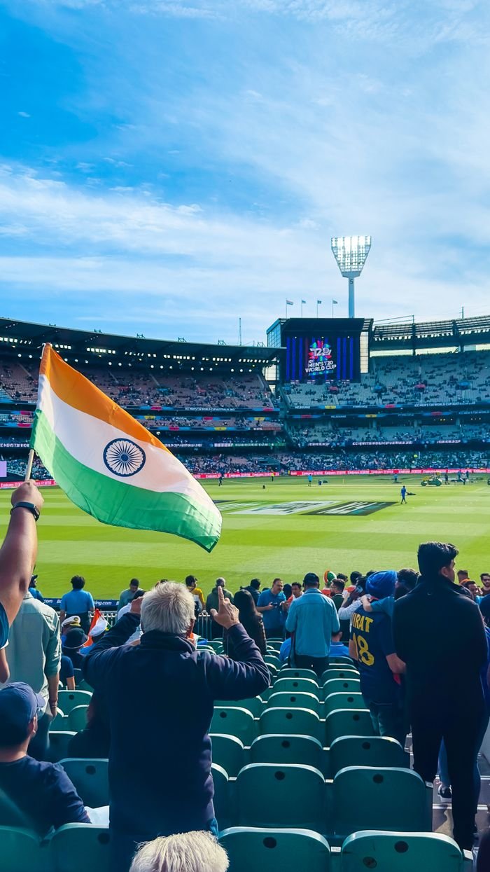 Menu Excited fans waving the Indian flag at Melbourne Cricket Ground during a cricket match.