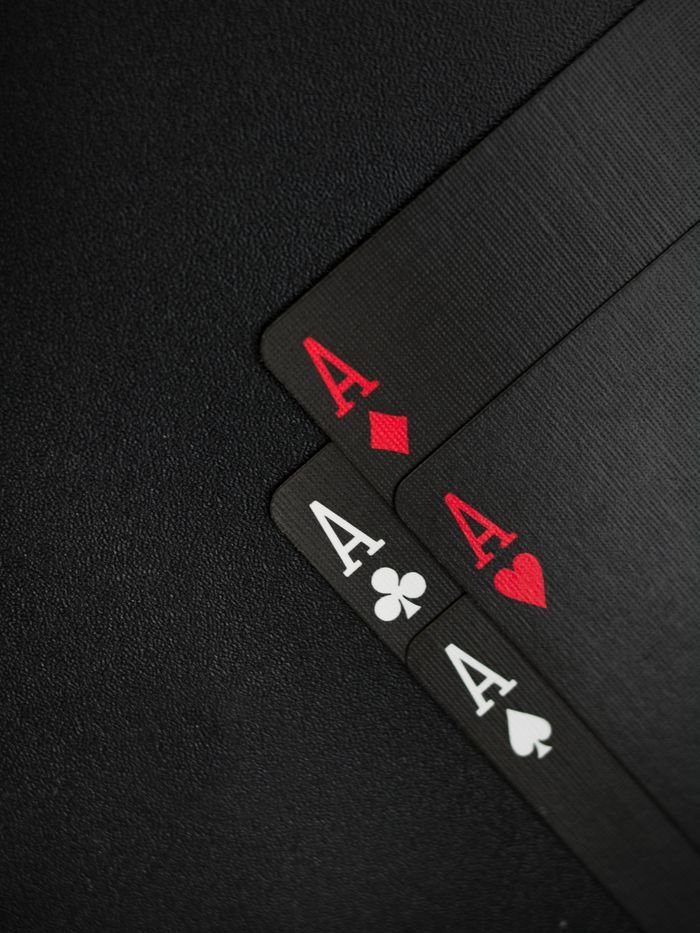 Menu Close-up of four aces on a black background, ideal for casino-themed content.