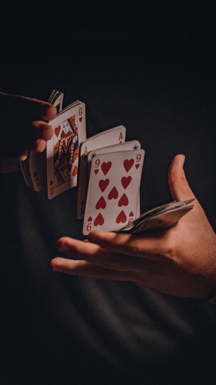 Menu A dramatic close-up of hands skillfully shuffling a deck of playing cards.